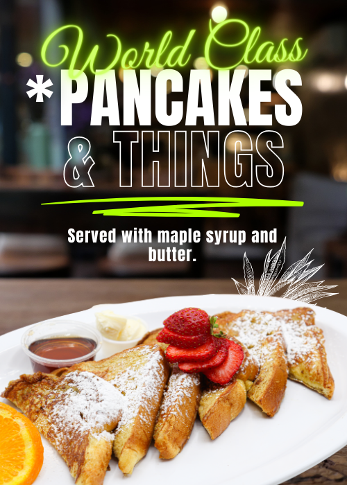 French toast with powdered sugar and strawberries with a side of syrup, butter and oranges